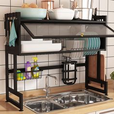 a kitchen sink with dishes and utensils on the shelf above it, in front of a tiled wall