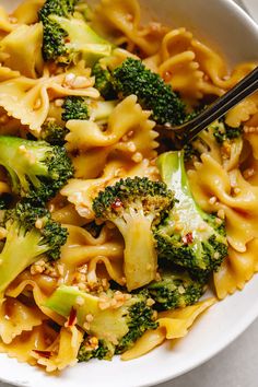 a white bowl filled with pasta and broccoli