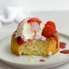 a piece of cake with ice cream and raspberries on top