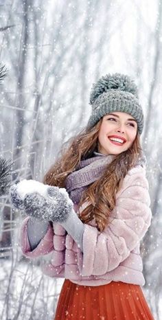 a beautiful young woman standing in the snow