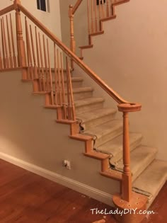 a wooden staircase with white railing and wood handrail