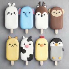 an assortment of ice creams with animals and cats on them are arranged in the shape of pops