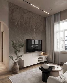 a living room with white furniture and a flat screen tv mounted to the side of a wall