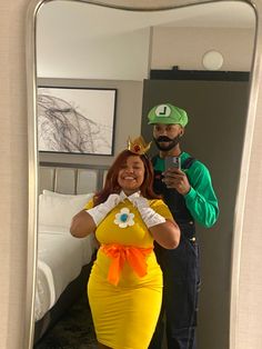 a man and woman dressed up in costumes taking a selfie while standing in front of a mirror