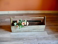 a wooden box with flowers in it on the floor