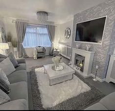 a living room filled with furniture and a flat screen tv mounted on the wall above a fire place