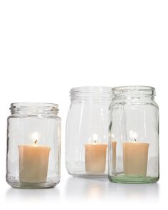 three jars filled with candles sitting next to each other