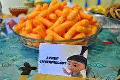 there is a bowl full of cheetos and a sign on the table that says i am not caterpillar