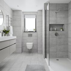 a bathroom with a toilet, sink and shower stall in the middle of the room