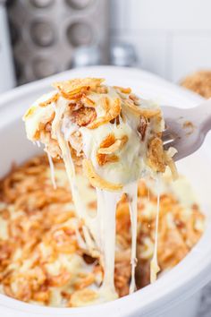 a spoon full of macaroni and cheese being lifted from the casserole