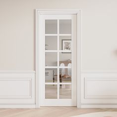 an empty room with white walls and wooden flooring is seen through the glass doors