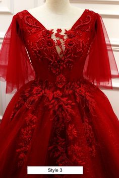 a red dress with sheer sleeves and flowers on it