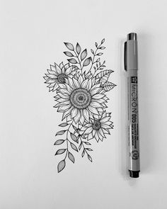 a pen is sitting next to a drawing of a sunflower