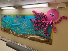 a bulletin board with an octopus and sea life on it's side in a school hallway