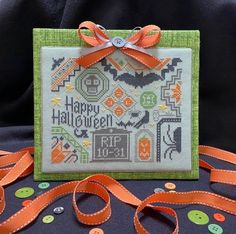 a cross stitch halloween card with orange ribbon