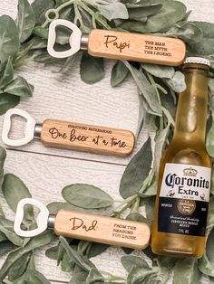 three bottle openers with personalized bottles on them sitting in front of a wreath