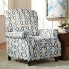 a living room with a blue and white patterned chair next to a potted plant