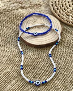 two blue and white beaded necklaces with an evil eye