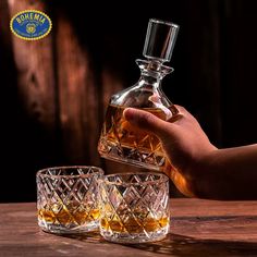 a hand is pouring whiskey into two glasses