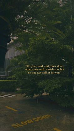 an empty parking lot with trees and a poem written on the ground next to it