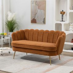 an orange couch sitting on top of a rug in a living room next to a white wall