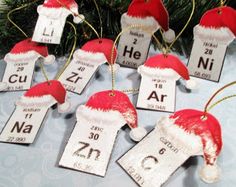 christmas themed ornaments are arranged on a table with blue and white fabric, including santa's hats