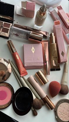 various makeup products are arranged on a white counter top, including blushes and lipstick