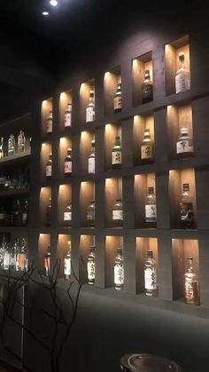 bottles are lined up on the wall in this dimly lit room, with dim lighting