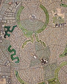 an aerial view of a circular maze in the middle of a park with lots of trees