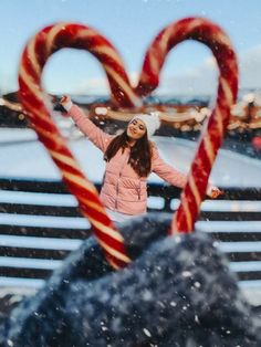 a woman standing in front of two candy canes