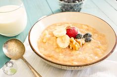 a bowl of oatmeal with fruit on top next to a glass of milk