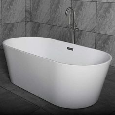 a large white bath tub sitting on top of a tiled floor next to a wall