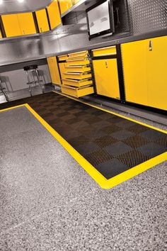 a garage with yellow cabinets and tools on the floor is shown in this 3d image