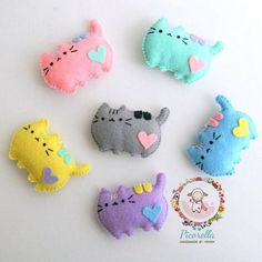 six felt cat brooches with hearts on them