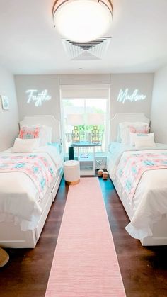 two twin beds in a bedroom with pink rug