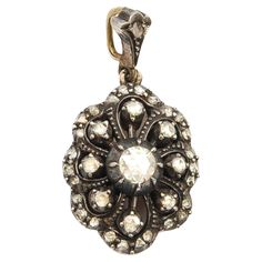 An antique floral rose cut diamond pendant, truly a treasure to behold. This early 20th Century oval-shaped pendant is created with many bright rose cut diamonds set in a silver and gold frame. The diamonds are set in a silver raised dome shaped mounting with mille griffe silver work in between the diamonds. The reverse of the pendant is created in 14 karat gold and has a grooved dome in the center. The lovely design of the pendant is reminiscent of a blooming flower. It is amazing the way the l Luxury Antique Necklaces With Rose Cut Diamonds, Ornate Rose Cut Diamond Pendant Jewelry, Victorian Rose Cut Diamond Pendant Jewelry, Rose Cut Diamond Pendant, Antique Floral, Floral Pendant, Antique Roses, Silver Work, Rose Cut Diamond