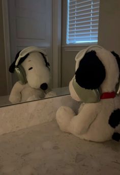 a stuffed dog sitting in front of a mirror with headphones on it's ears