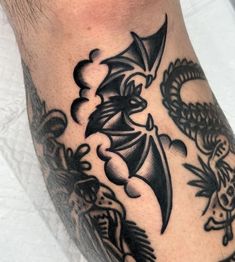 a black and white tattoo on the leg of a man's arm with an image of a dragon