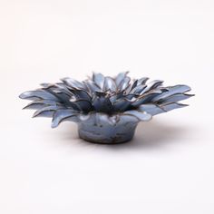 a small blue vase sitting on top of a white table