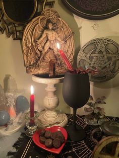 a candle is lit on top of a table with cookies and other items in front of it