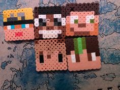 three perler beads are sitting on top of a map, each with different characters