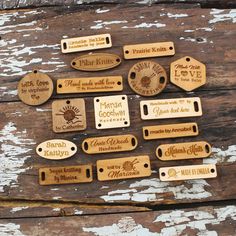 some wooden tags are laying on top of a piece of old wood and have been engraved onto them