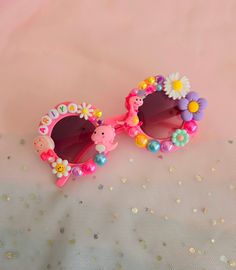 a pair of pink sunglasses with flowers on them