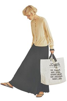 a woman in a long skirt carrying two shopping bags and looking down at the ground