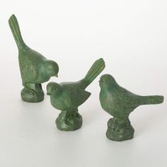 three green birds sitting on top of each other