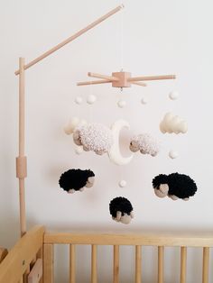 a crib with sheeps hanging from it's sides