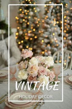 a dining room table with pink and white flowers on it, in front of a christmas tree