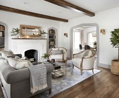 a living room filled with furniture and a fire place in the middle of a room