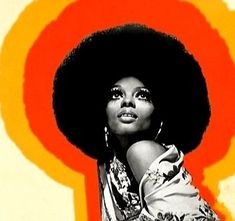 a woman with an afro standing in front of a red and orange background