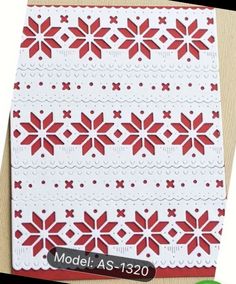 a red and white christmas card with snowflakes on it, sitting on a table